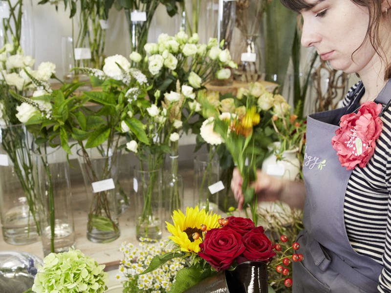 A member of staff arranging flowers at Plantology.