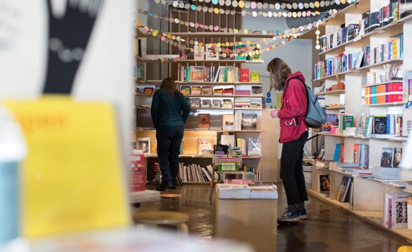 Inside the books and magazine specialist Labibliotek who are based in Kommune. People are browsing the shelves of books.