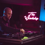 A man plays music at a DJ desk.