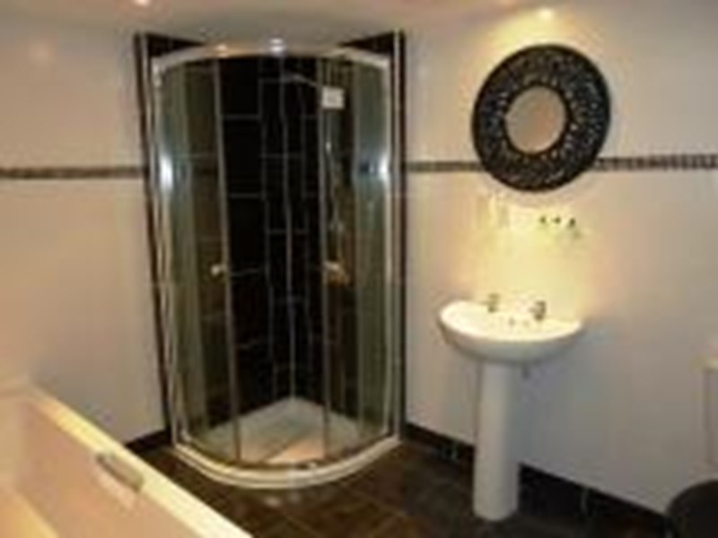 shower room with a walk-in shower and sink, featuring clean and modern fixtures.