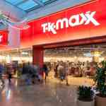 The brightly lit TK Maxx store at Meadowhall with a large red sign above the entrance and shoppers walking past on the polished indoor concourse.